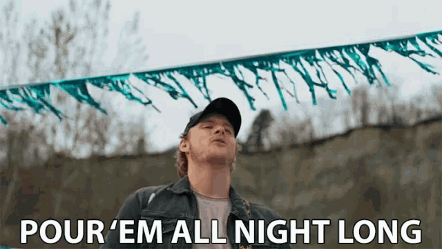 a man is standing in front of a banner that says pour em all night long