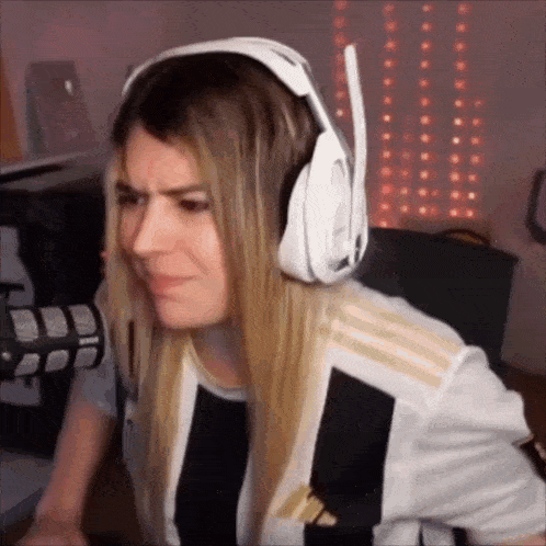 a woman wearing headphones and a black and white shirt is making a funny face .