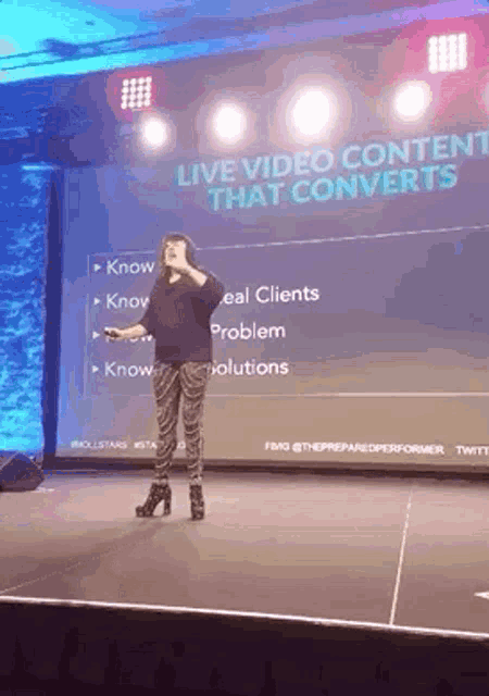 a woman is standing on a stage giving a presentation about live video content that converts