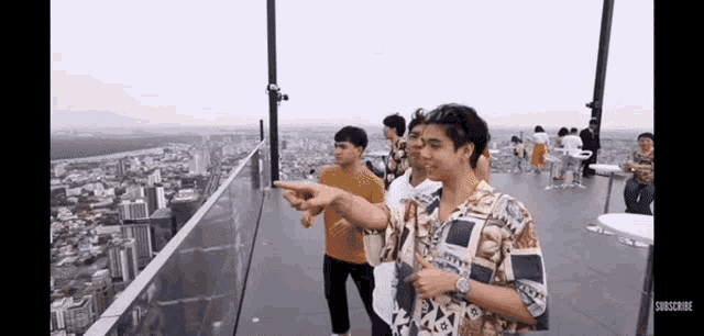 a group of people are standing on top of a building .
