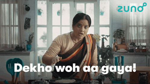a woman is cooking in a kitchen with the words dekho woh aa gaya behind her