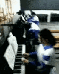 a group of people are playing a piano in a room