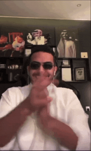 a man wearing sunglasses and ear buds is giving a thumbs up