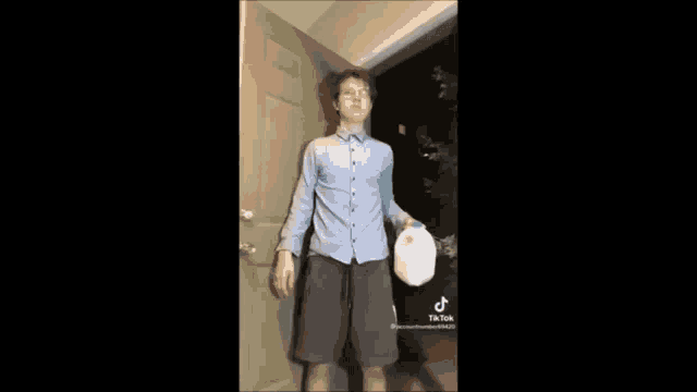 a person is standing in a doorway in a dark room with a ghost behind them .