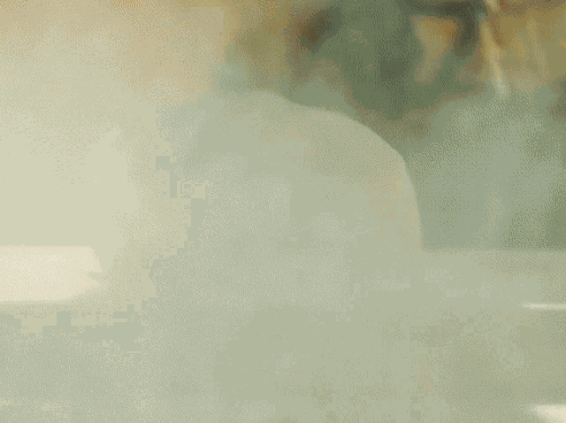 a blurred image of a person 's face with smoke coming out of their mouth