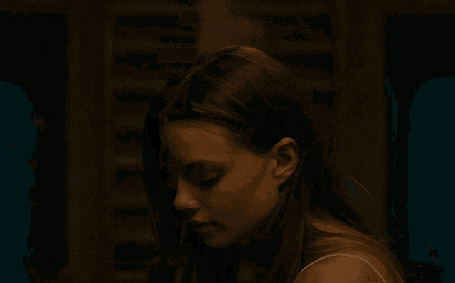 a woman with long hair and a nose ring is looking at the camera