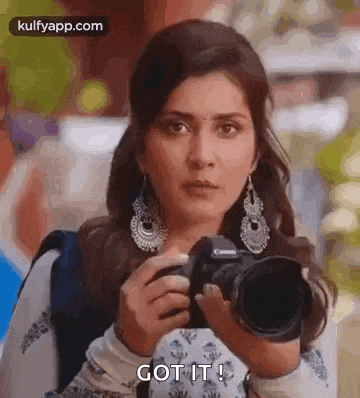 a woman is holding a camera and taking a picture of something .