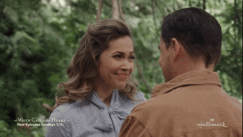 a man and woman are looking at each other in a hallmark movie
