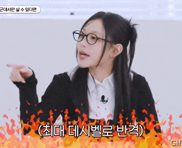 a woman wearing glasses and a black jacket is pointing at something in a foreign language