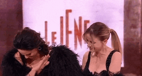 two women are standing next to each other in front of a sign that says le tene .