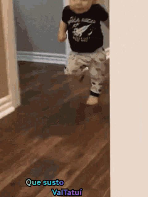 a baby is walking on a wooden floor with the words que susto valtatui on the bottom
