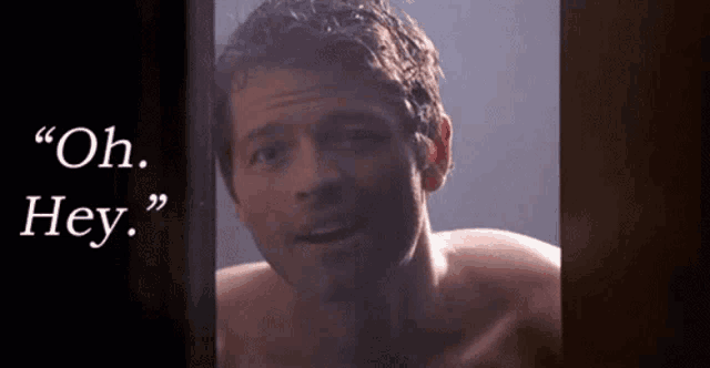 a shirtless man is standing in front of a door with the words `` oh hey '' written on it .