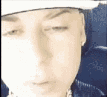 a close up of a person 's face with a hat on