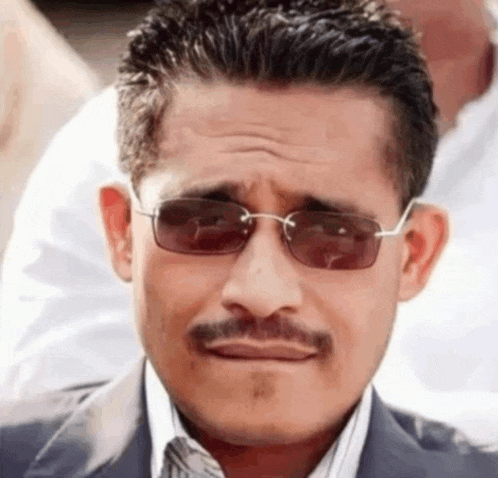 a man with a mustache and sunglasses is making a funny face