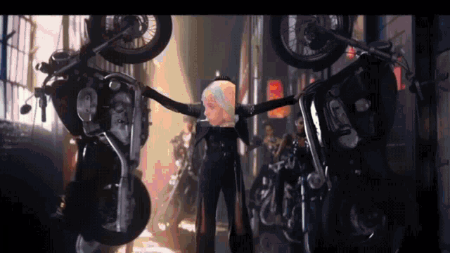 a woman is standing in front of a bunch of motorcycles with her arms outstretched