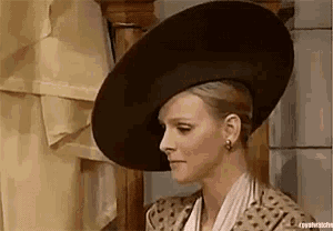 a woman wearing a large hat and a leopard print jacket is standing in front of a mirror .