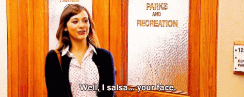 a woman is standing in front of a door that says `` well i salsa your face '' .