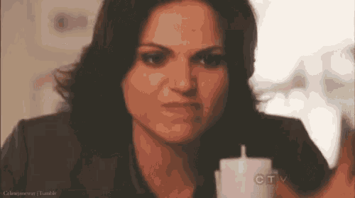 a woman is holding a candle and making an angry face