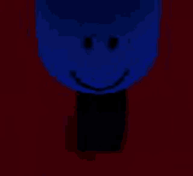 a blue object with a smiley face on it is sitting on a red surface .