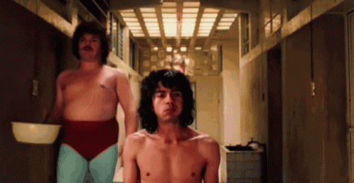 a man without a shirt is standing next to another man