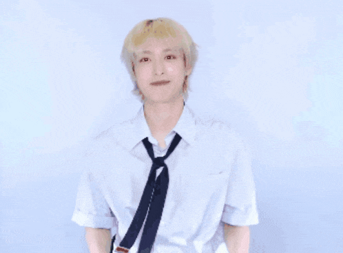 a young man wearing a white shirt and tie with his hands outstretched