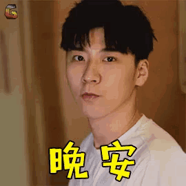 a young man in a white shirt is making a funny face with chinese writing on his face .