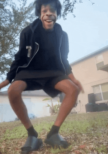 a man wearing a black jacket and shorts with the letter t on it