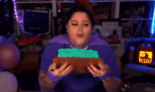 a woman wearing purple gloves is holding a piece of bread in front of her face .