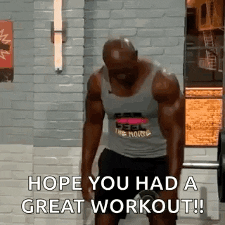 a man in a tank top is lifting a dumbbell in a gym .