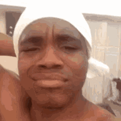 a shirtless man wearing a white bandana on his head .