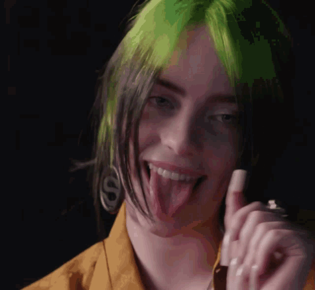 a woman with green hair sticking out her tongue