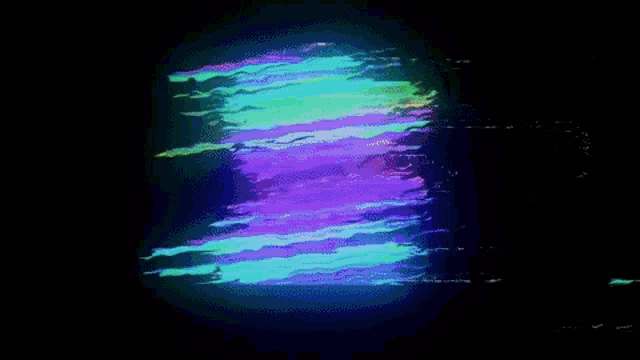 a black background with a green and purple glowing object in the middle