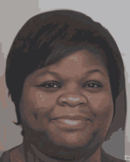 a woman with short black hair smiles for the camera