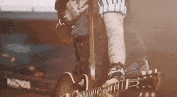 a man playing a guitar with the letter r on the neck