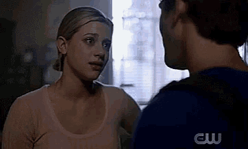 a man and a woman are standing next to each other and looking at each other in a room .
