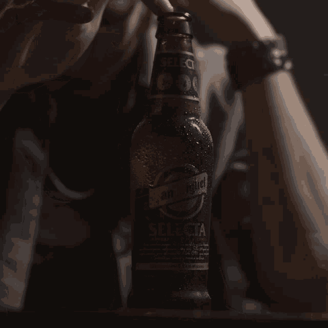 a person holds a bottle of selecta beer in their hand