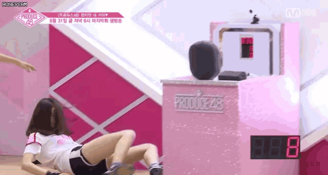 a woman is laying on the floor next to a box that says produce 48 on it .