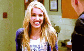 a woman with blonde hair is smiling in front of a man in a kitchen