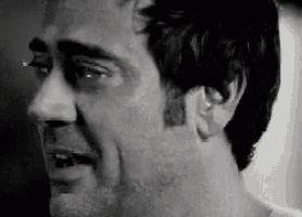 a black and white photo of a man 's face with tears running down his face .