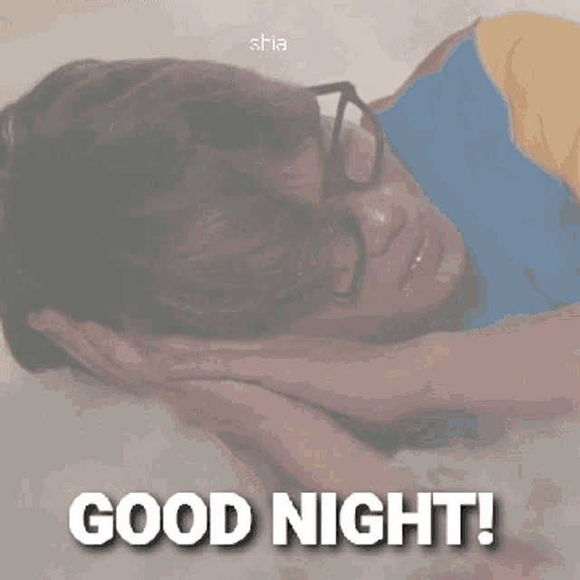 a man with glasses is laying on a bed with the words good night written on the bottom