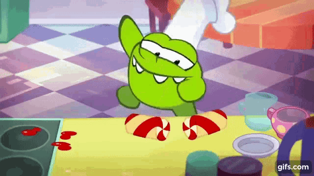 a green cartoon character is standing on a table with candy canes