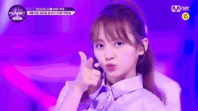 a girl is giving a thumbs up sign while wearing a purple shirt .