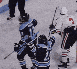 a hockey player with the number 11 on his jersey is celebrating