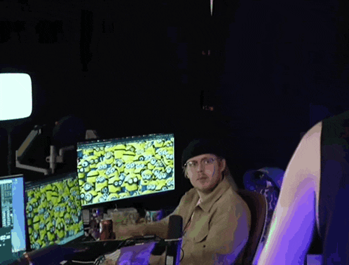 a man is sitting in front of a computer screen with a minion on it