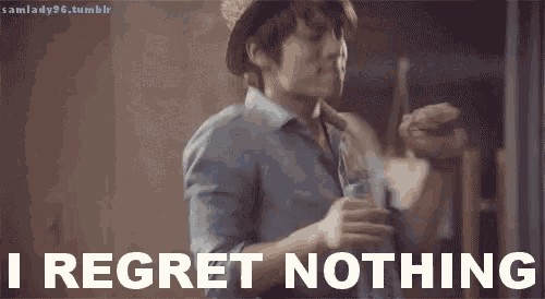 a man in a hat says i regret nothing while holding a drink