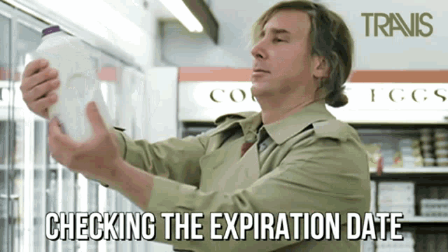 a man checking the expiration date of a milk carton