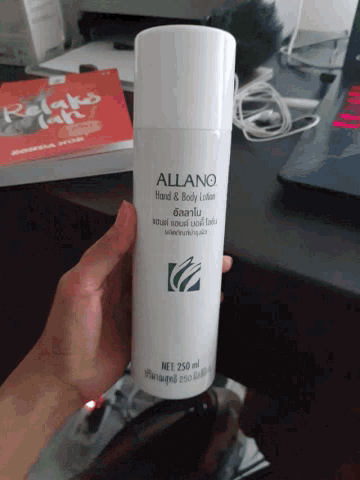 a person is holding a bottle of allano hand & body lotion