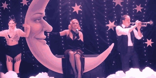 a woman sits on a crescent moon while a man plays the trumpet