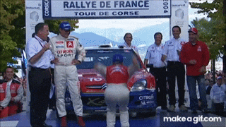 a group of people standing in front of a rallye de france sign