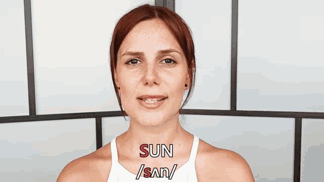 a woman wearing a white tank top with the word sun on her neck